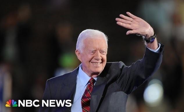 Jimmy Carter w trakcie działalności humanitarnej, np. budując dom z Habitat for Humanity, ukazujący jego zaangażowanie i ciepło.