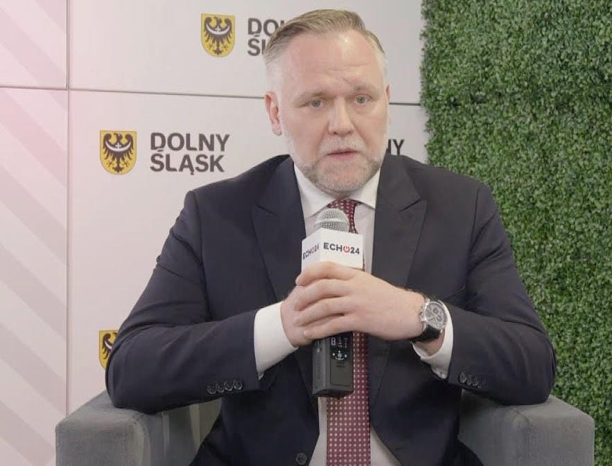 Symboliczne przedstawienie kariery Dawida Jackiewicza, łączące motywy polityczne (parlament) z energetycznymi (turbiny wiatrowe), ukazujące jego różnorodne osiągnięcia.
