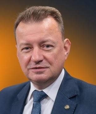 Służbowa limuzyna zaparkowana przed kinem, z synami Mariusza Błaszczaka wychodzącymi z pojazdu na premierze filmu.