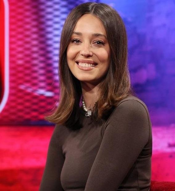 Izabella Krzan w dynamicznej pozie, na planie telewizyjnym lub podczas występu, ukazująca jej energię i profesjonalizm jako prezenterka.