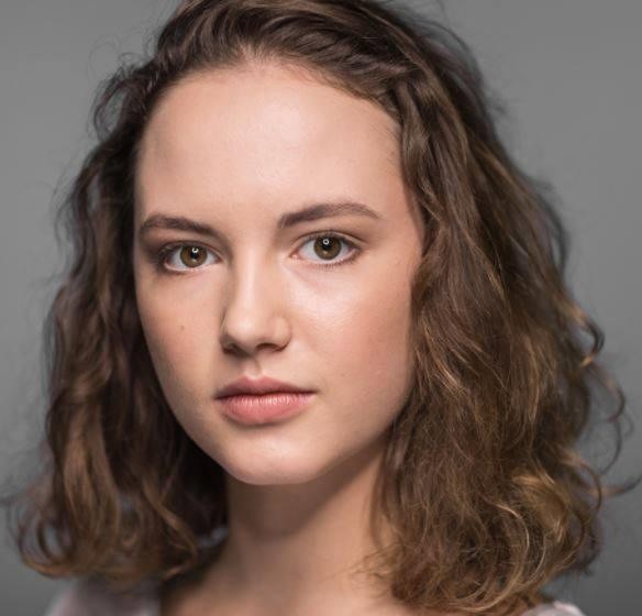 Martyna Byczkowska na planie filmowym, w stroju nawiązującym do jednej z jej ról, skupiona na pracy, co podkreśla jej profesjonalizm i zaangażowanie.