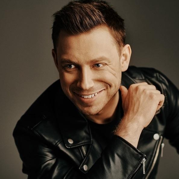 Paweł Jasionowski na scenie podczas koncertu Masters, śpiewający z pasją.
