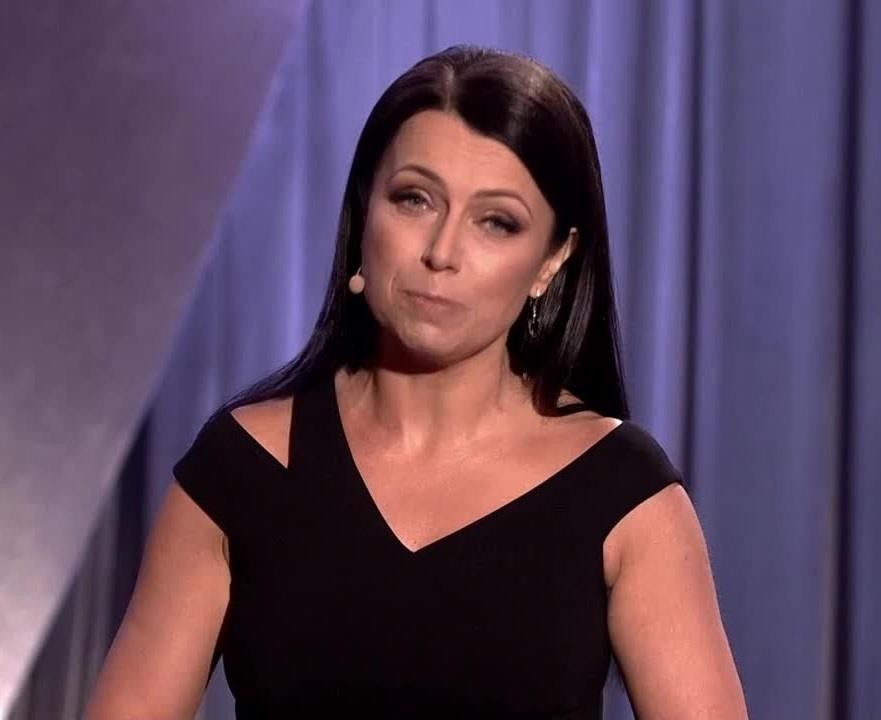 Adrianna Borek na scenie kabaretowej w charakterystycznej pozie, ukazująca swoją ekspresję i humor.