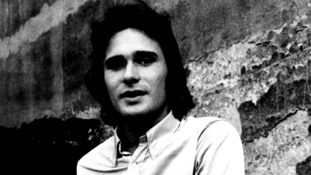 Jerzy Grunwald na scenie w latach 70., grający na gitarze lub śpiewający, z zespołem w tle, w stylu fotografii koncertowej.