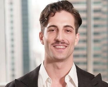 Damiano David na scenie, uśmiechnięty i nawiązujący kontakt z publicznością, w tle rozmyte postacie fanów.