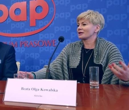 Beata Olga Kowalska uśmiechająca się i pozująca, być może w trakcie spotkania z fanami lub w swobodnej, publicznej scenerii, odzwierciedlająca jej przystępną osobowość prezentowaną na Instagramie.
