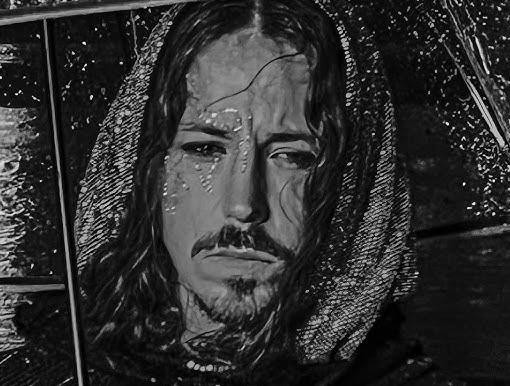 Michał Szpak podczas energicznego występu na scenie, śpiewający do mikrofonu, z charakterystycznymi długimi włosami i makijażem, w otoczeniu dynamicznego oświetlenia scenicznego.